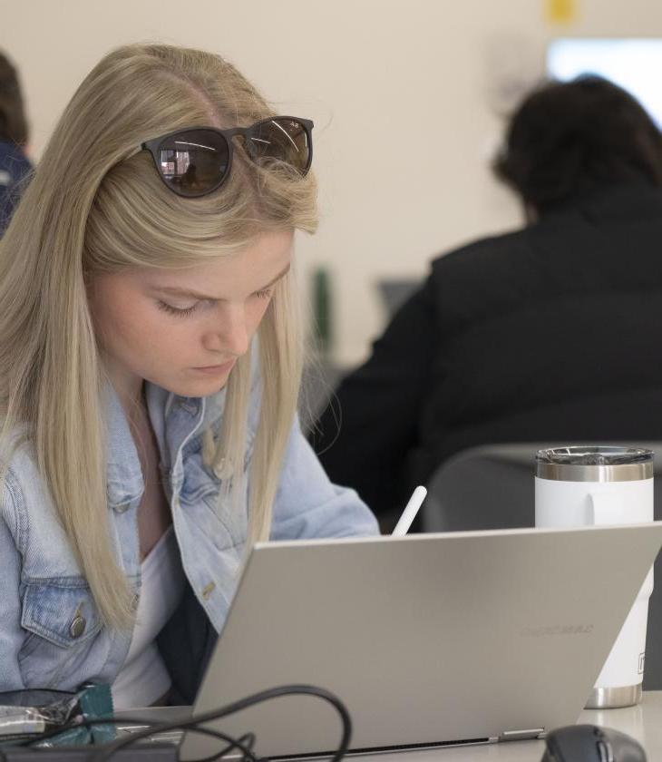 student at a laptop in a classroom 